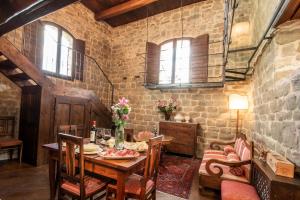 a dining room with a table and chairs and a brick wall at Medieval Tower Lungarno your wedding in Tuscany in Pratovecchio