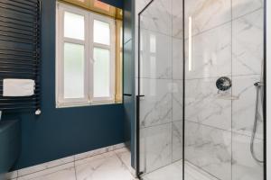 a bathroom with a shower with a glass door at Poznań City Center Sikorskiego by Renters in Poznań