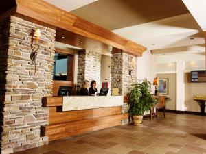 two people sitting at a counter in a lobby at Hotel L'Oie des neiges in Lévis