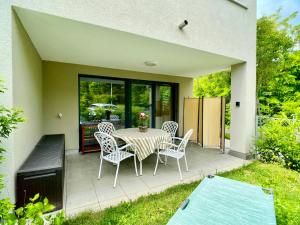 une terrasse avec une table et des chaises. dans l'établissement Stilvolles Apartment «Coco» am Bodensee, à Hörbranz