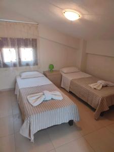 a bedroom with two beds with towels on them at Maisonette In Paradisos in Neos Marmaras