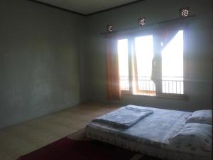 um quarto com uma cama em frente a uma janela em Villa bhifa Puncak em Bogor
