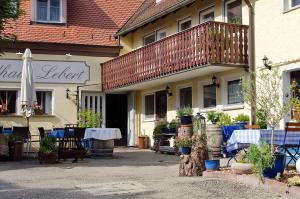 ein Gebäude mit einem Tisch und einem Balkon darauf in der Unterkunft Landhaus Lebert Restaurant in Windelsbach