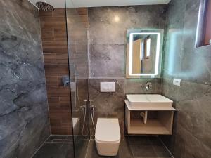 a bathroom with a toilet and a sink and a shower at Vila Anxhelo in Ksamil