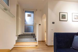 a stairway with a blue couch and a window at Studio Rivoli Loft in Milan