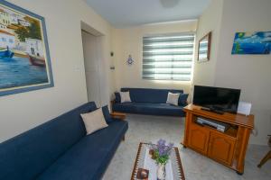 un soggiorno con divano blu e TV di The Blue Mile a Paralimni