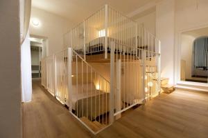 a white spiral staircase in a room with wooden floors at Studio Rivoli Loft in Milan