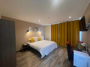 - une chambre avec un lit et un rideau jaune dans l'établissement Leclerc Hotel Centre Gare, au Mans