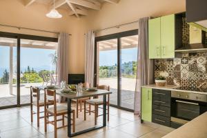 eine Küche und ein Esszimmer mit einem Tisch und Stühlen in der Unterkunft Saint Nicholas Villas 3 in Skala