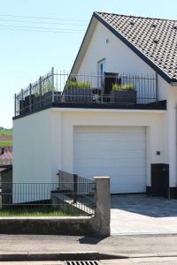 a white house with two garage doors and a balcony at Ferienwohnung Kondic in Burgau