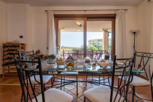 comedor con mesa con sillas y mesa de cristal en Sardinia Guest House, en Olmedo