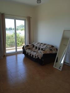 a bedroom with a bed and a large window at Nereids Apartments-Agavi in Petalidi