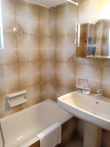 La salle de bains est pourvue d'une baignoire blanche et d'un lavabo. dans l'établissement Nereids Apartments-Agavi, à Petalidhion