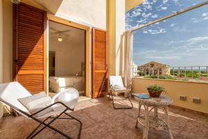 een balkon met witte stoelen en een bed en een tafel bij Sardinia Guest House in Olmedo