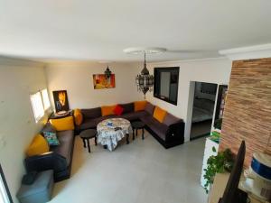 a living room with a couch and a table at Maison 3 chambres Imi ouaddar in Agadir nʼ Aït Sa