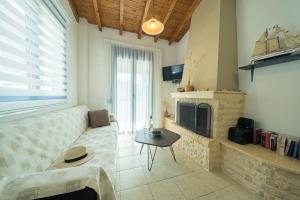 a living room with a couch and a fireplace at Sunset Home Crete in Paránimfoi