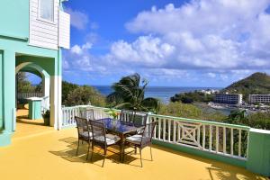 una mesa y sillas en un balcón con vistas al océano en BeachFront Villa, en Gros Islet