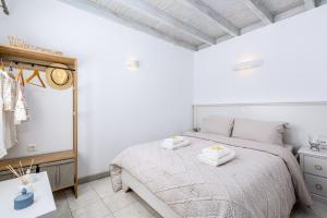 a bedroom with a bed with two towels on it at Amazing View Villa Oia with Jacuzzi in Oia