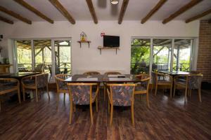 a dining room with tables and chairs and a television at Sunrise Glamping Retreat in Galeşu