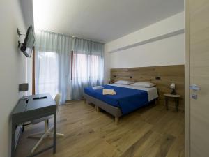 a bedroom with a blue bed and a desk at Apartment Marco in Teramo