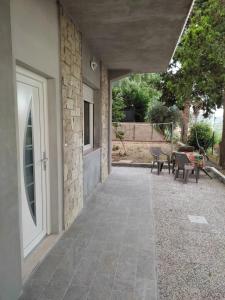 een patio met een deur en een tafel en stoelen bij Villa Paoletti, appartamento confortevole nel cuore di Gradara in Gradara