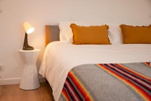 a bedroom with a bed with yellow pillows and a lamp at Palmira's - relaxing countryside house in Batalha in Batalha