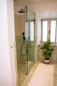y baño con ducha y planta. en Palmira's - relaxing countryside house in Batalha, en Batalha