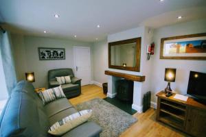 a living room with a couch and a fireplace at Riverside Cottage 6 guests 4 adults max hot tub in Backbarrow