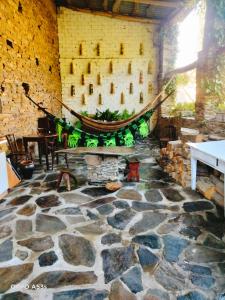 um quarto com piso de pedra e uma rede de descanso na parede em Pensión Santa Rosa em Samos