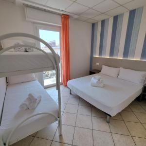 een slaapkamer met 2 stapelbedden en een raam bij Residence Mare in Rimini