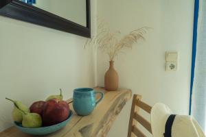 a table with a bowl of fruit and a cup on it at Sunset Home Crete in Paránimfoi