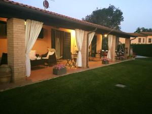 eine Terrasse mit weißen Vorhängen auf einem Haus in der Unterkunft Le Siepi in Magliano in Toscana