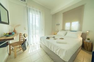 a bedroom with a large white bed and a desk at Sunset Home Crete in Paránimfoi