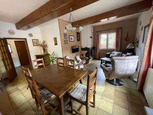 een woonkamer met een houten tafel en stoelen bij Maison chaleureuse au coeur des Aspres in Camélas