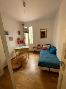 sypialnia z łóżkiem i biurkiem w obiekcie Maison chaleureuse au coeur des Aspres w mieście Camélas