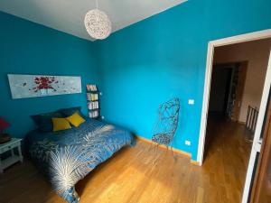 niebieska sypialnia z łóżkiem i krzesłem w obiekcie Maison chaleureuse au coeur des Aspres w mieście Camélas +8 zdjęć