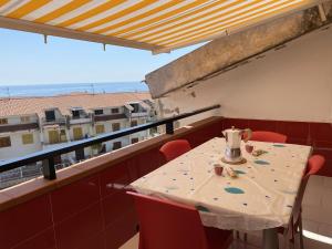 einen Tisch und Stühle auf einem Balkon mit Meerblick in der Unterkunft Un Raggio di Sole in Scalea