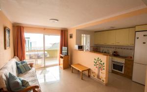 eine Küche mit einem Sofa und einem Tisch in einem Zimmer in der Unterkunft Bonito apartamento cerca de la playa, planta alta. in Cala de Finestrat