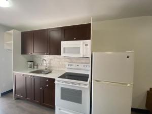 a kitchen with a white refrigerator and a white microwave at Mountain View Motel in Smithers