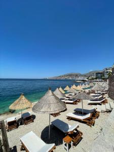 un grupo de sombrillas y sillas en una playa en Blue Bay Hotel, en Sarandë