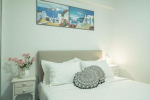 a white bed with a pillow on top of it at Sunset Home Crete in Paránimfoi