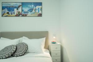 a bedroom with a bed with pillows and a night stand at Sunset Home Crete in Paránimfoi