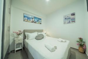 a bedroom with a white bed and a night stand at Sunset Home Crete in Paránimfoi