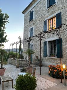 ein Steingebäude mit blauen Fensterläden und einem Fenster in der Unterkunft Hôtel du Moulin in Allemagne-en-Provence