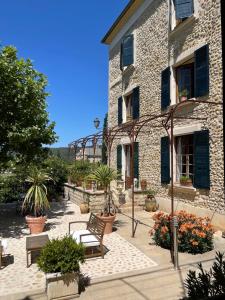 budynek z ławkami i roślinami przed nim w obiekcie Hôtel du Moulin w mieście Allemagne-en-Provence