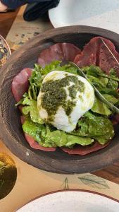 a plate of food with an egg on lettuce and meat at Toka Hotel Restaurant in Pogradec