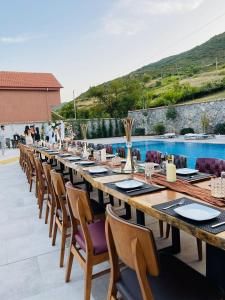 a long wooden table with chairs and a pool at Toka Hotel Restaurant in Pogradec