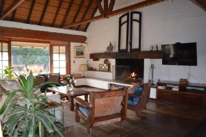 a living room with a table and a fireplace at Divina casa en Carrasco con piscina in Montevideo