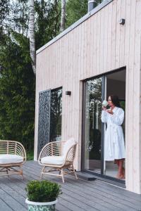 a woman in a white dress standing in a window at River Cabin in Inciems
