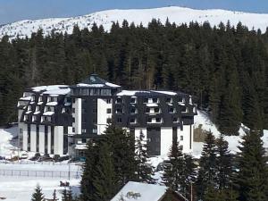 a large building in the snow in front of a mountain at Apartmani A in Kopaonik